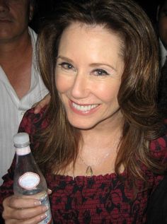 a smiling woman holding a bottle of water