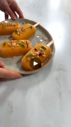 a person is reaching for some food on a plate with toothpicks in it