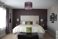 a bedroom with purple walls and white bedding