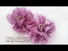 two purple flowers are sitting on a white surface with the words wede collections written below it