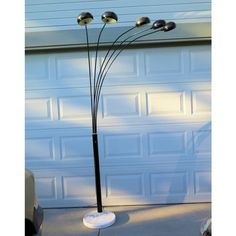 a lamp that is sitting in front of a garage door with four lights on it