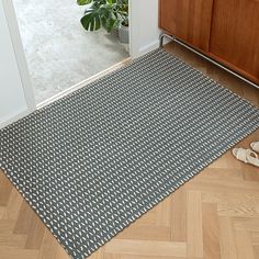 a black and white rug sitting on top of a wooden floor next to a door