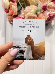 a person holding up a save the date card