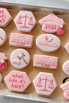 pink and white decorated cookies in a box with the names of different court judges on them