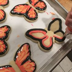 some cookies are decorated with orange and black butterflies