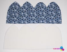 a blue and white paper crown with polka dots on the top is cut out to look like it's made from construction paper