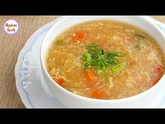 a white bowl filled with soup on top of a wooden table