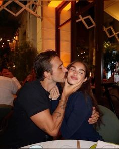 a man kissing a woman on the cheek at a restaurant