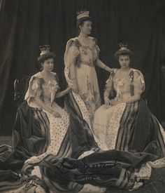 three women in dresses and tiaras posing for a photo