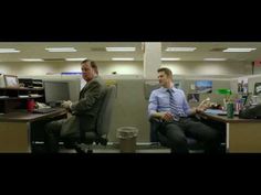 two men sitting at desks in an office