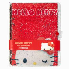 a hello kitty notebook with glitters on the cover and red writing in white lettering