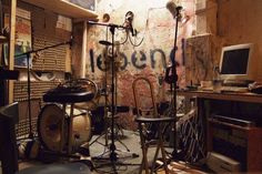 a recording studio with lots of equipment and sound equipment in front of a wall that has graffiti on it