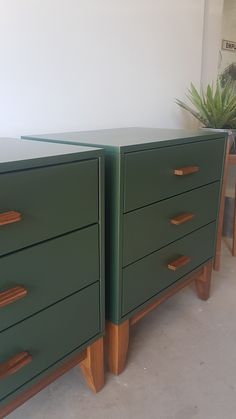 two green dressers sitting next to each other on top of a cement floor in front of a white wall