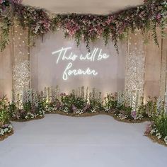 a wedding stage with flowers and greenery on the wall that says, this will be heaven