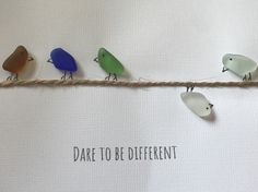 five birds are sitting on a rope with the words dare to be different