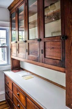 a wooden cabinet sitting next to a window