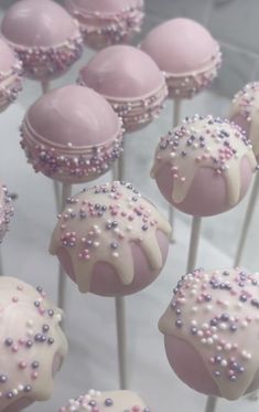 pink and white cake pops with sprinkles on them