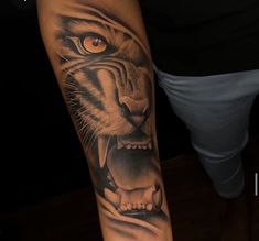 a man with a tiger tattoo on his arm and leg, showing it's teeth