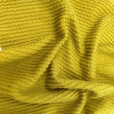 a yellow knitted fabric with some white buttons