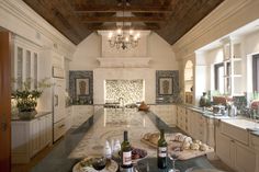 a kitchen filled with lots of counter top space and bottles of wine on the counter