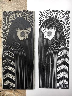 two black and white paper cut art pieces on wooden planks, one with a woman's face in the middle