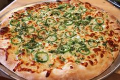 a pizza sitting on top of a metal pan covered in cheese and veggies