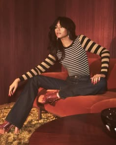 a woman sitting on top of a red couch