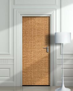 the door is made out of straw and has a lamp on it next to it