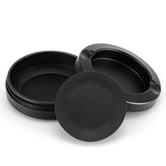 three black bowls with lids are stacked on top of each other in front of a white background