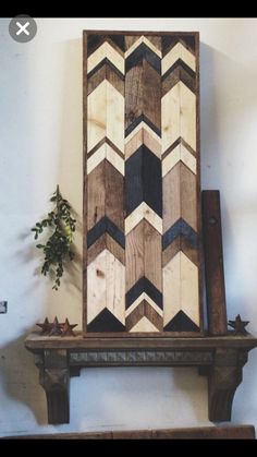 a wooden art piece sitting on top of a shelf next to a potted plant