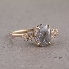 a close up of a ring with a stone in the middle and diamonds around it