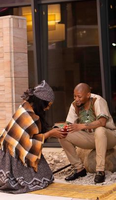 a man kneeling down next to a woman