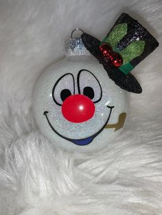 a white ornament with a clown nose and hat on it's head