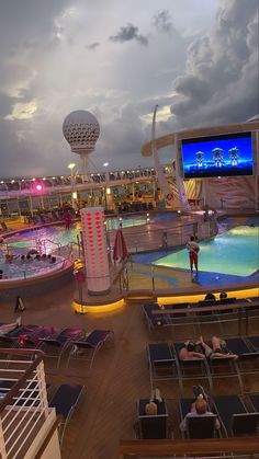 people are sitting in lounge chairs on the deck of a cruise ship, watching tv