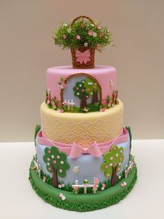 a three tiered cake decorated with trees and flowers