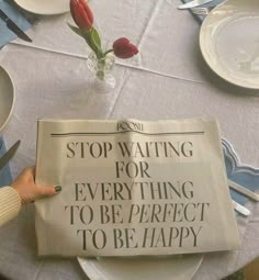 a person is holding up a newspaper that reads stop waiting for everything to be perfect to be happy