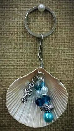 a seashell keychain with sea shells and pearls on it's side