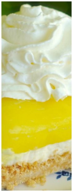 a piece of cake with white frosting and yellow icing sitting on a plate