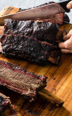 someone is cutting up some meat on a wooden board