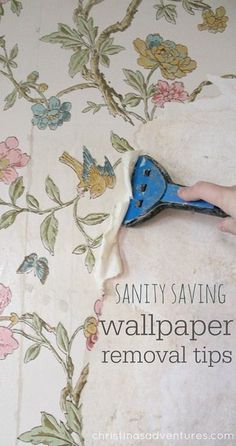 someone using a wallpaper removal tool to remove the fabric