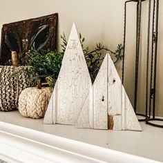 three wooden trees sitting on top of a mantle