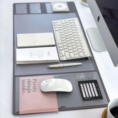 a desk with a keyboard, mouse and other items on it next to a cup of coffee