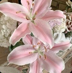 some pink flowers are in a vase on a table