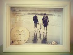 two people walking on the beach with a dog in front of them and a life preserver