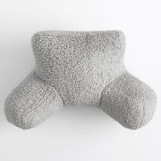 a gray pillow sitting on top of a white wall