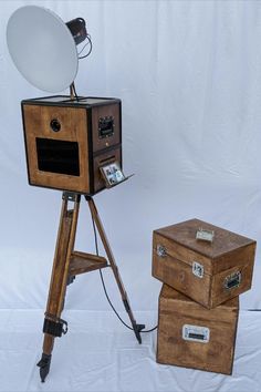 an old fashioned camera on a tripod with two boxes and a mirror in front