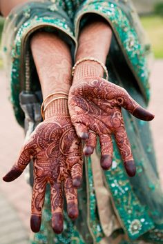 a woman's hands with hennap on her arm and hand in the middle