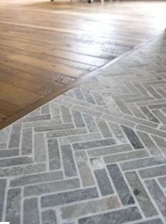 an empty living room with wood floors and tile