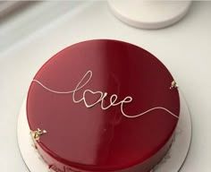 a red cake with the word love written on it