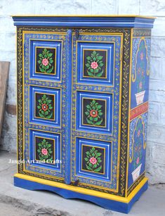 a blue and yellow cabinet with flowers painted on it